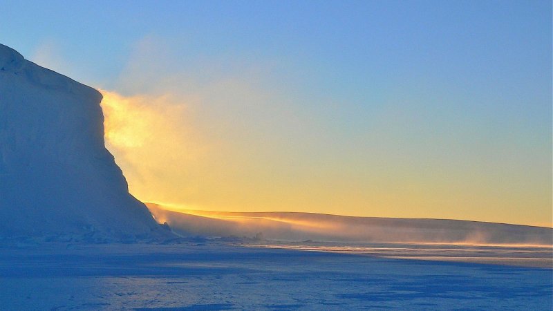 夕日に染まる氷壁と雪原（極地）